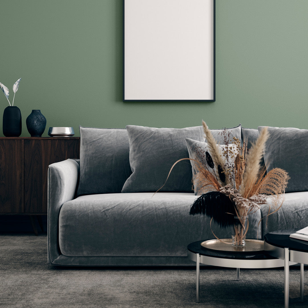 A living room painted in Zhoosh's Emerald Bay, a pale sage green paint in flat matt. 