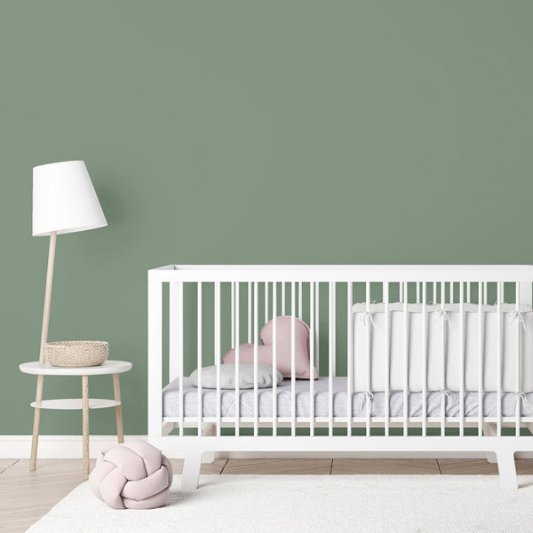 A nursery painted in Zhoosh's child-safe Emerald Bay, a pale sage green paint in flat matt. 