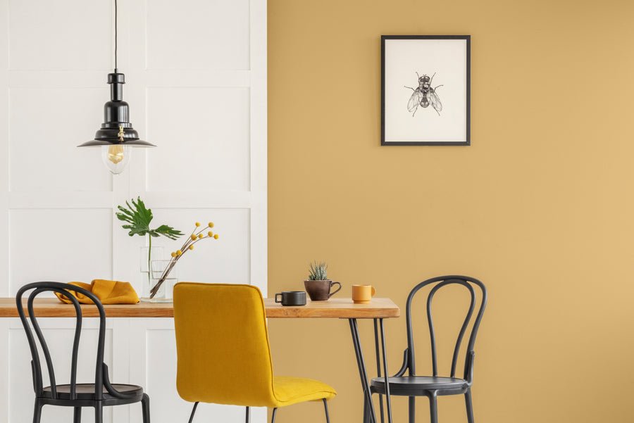 Dining room with walls decorated in Beehive golden yellow paint colour.