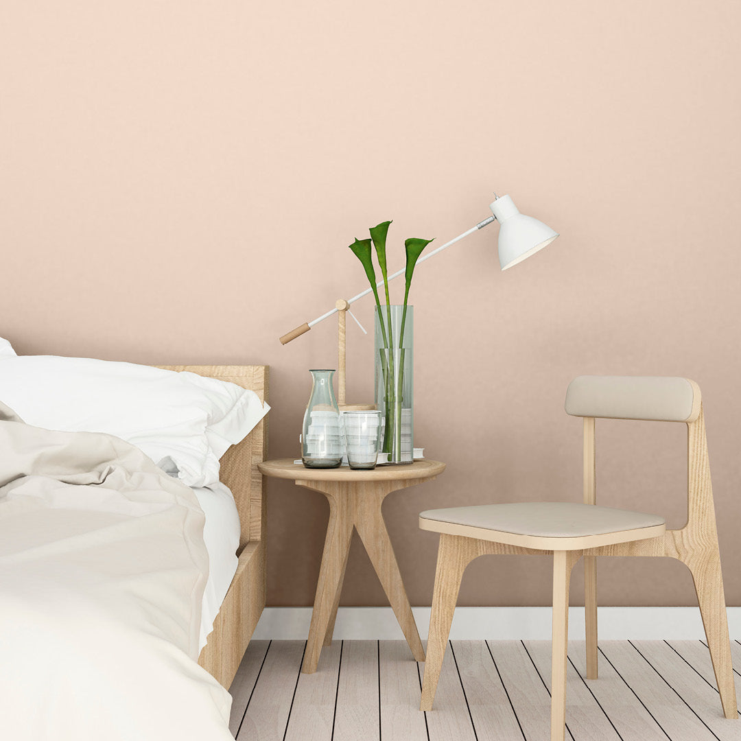 Minimalist bedroom set against a wall decorated with Rosebud, a pink beige paint from Zhoosh.