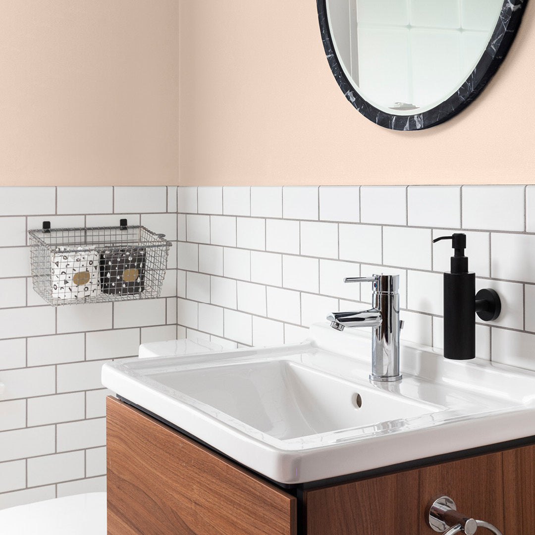 Classic bathroom set against a wall decorated with Rosebud, a pink beige paint from Zhoosh.